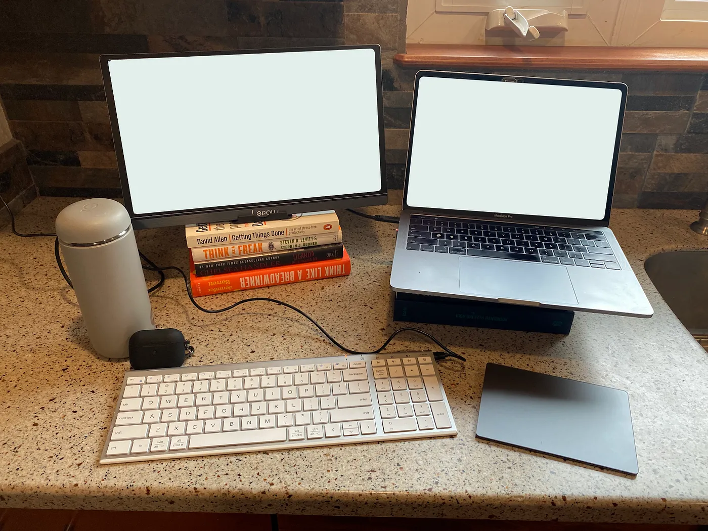 My digital nomad workspace setup with portable monitor, laptop stand, external keyboard and trackpad